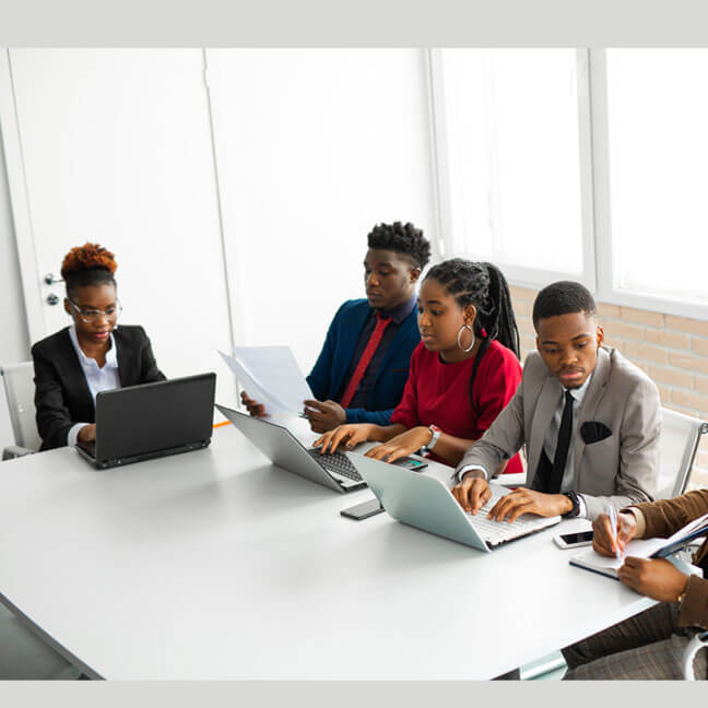 A group of teachers planning together with Zyqual's Lesson Plan Portal on a laptop.